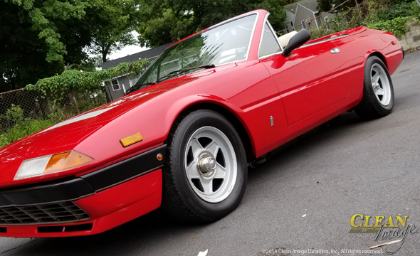 Red Ferrari convertible top down and freshly cleaned.